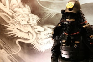 A figure in armor with a helmet and a shield, standing in front of a wall with a dragon design. - Satsukian (Kyoto)