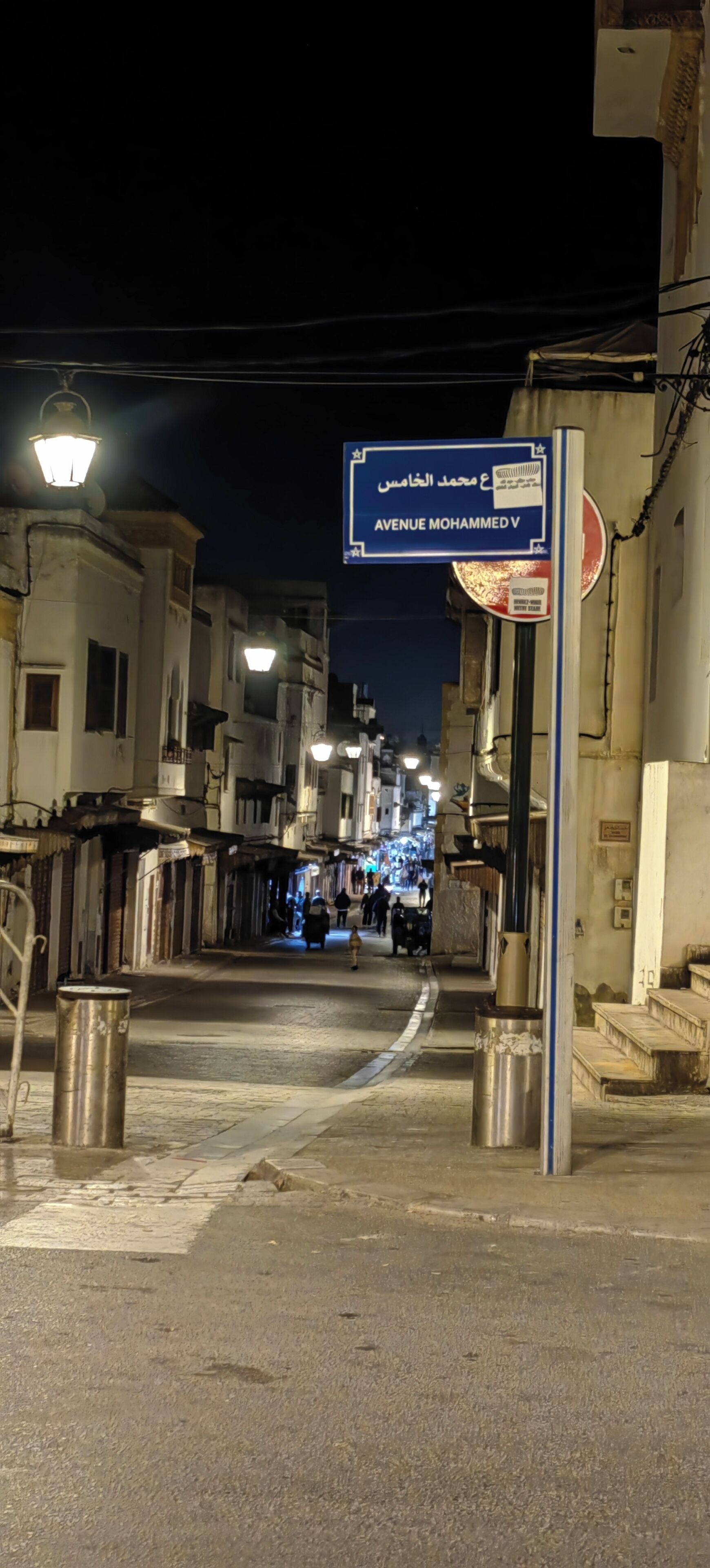 A street at night with a sign for Avenue Mohammed V.