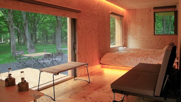 A wooden interior with a bed, a table, and a bench. - Akaigawa Tomo Playpark Jubako (Akaigawa)