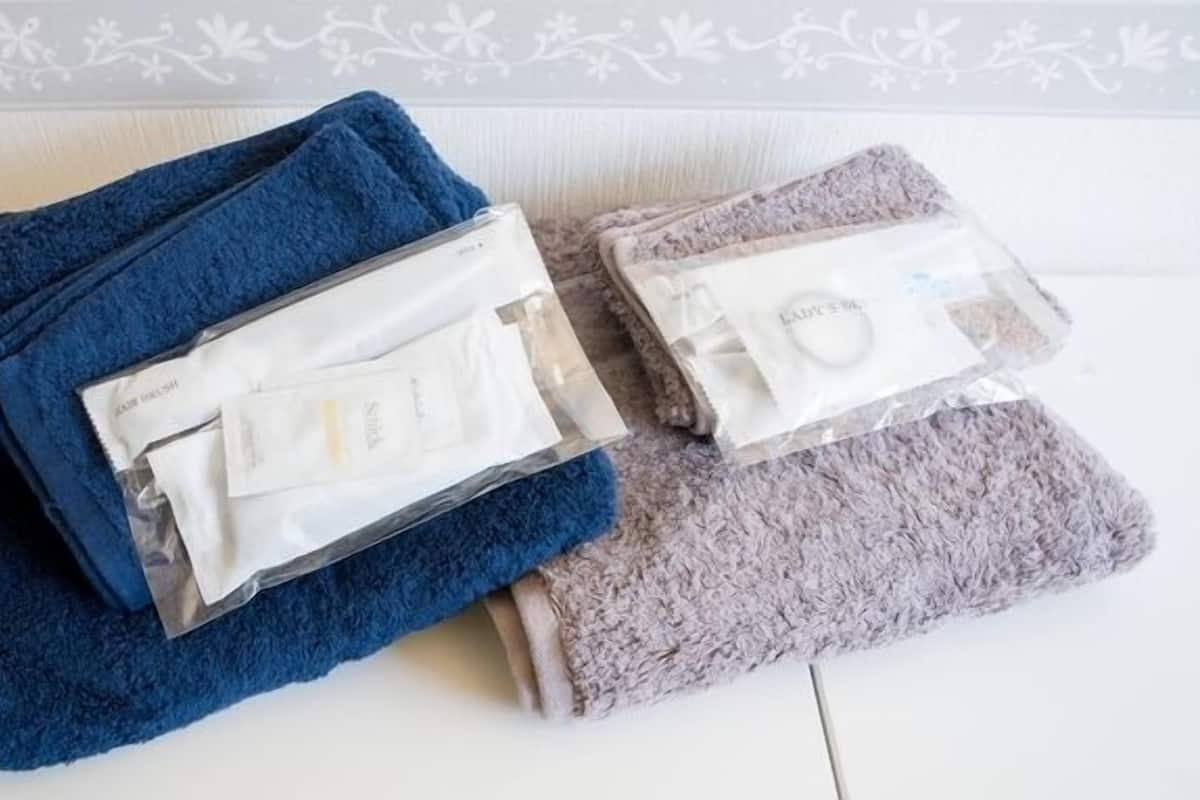 Une pièce avec un mur blanc et une bordure à motifs, une serviette bleue et une serviette grise.