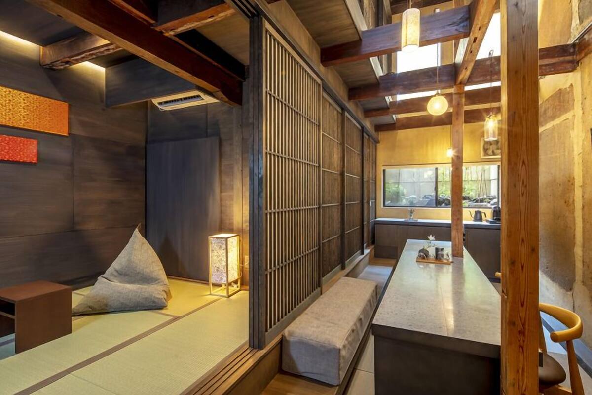 A traditional Japanese-style room with tatami flooring, a low table, and a sliding door.
