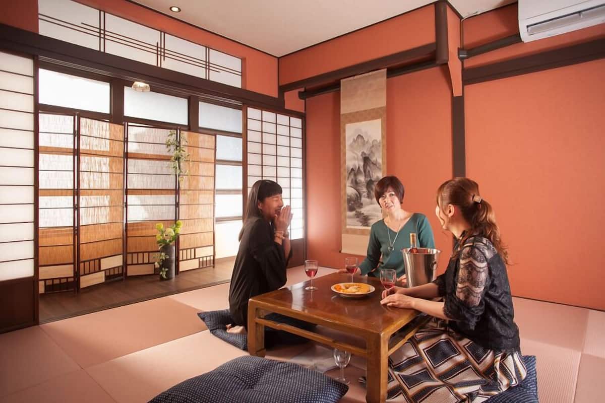 A traditional Japanese room with tatami flooring, a low table, and sliding doors.