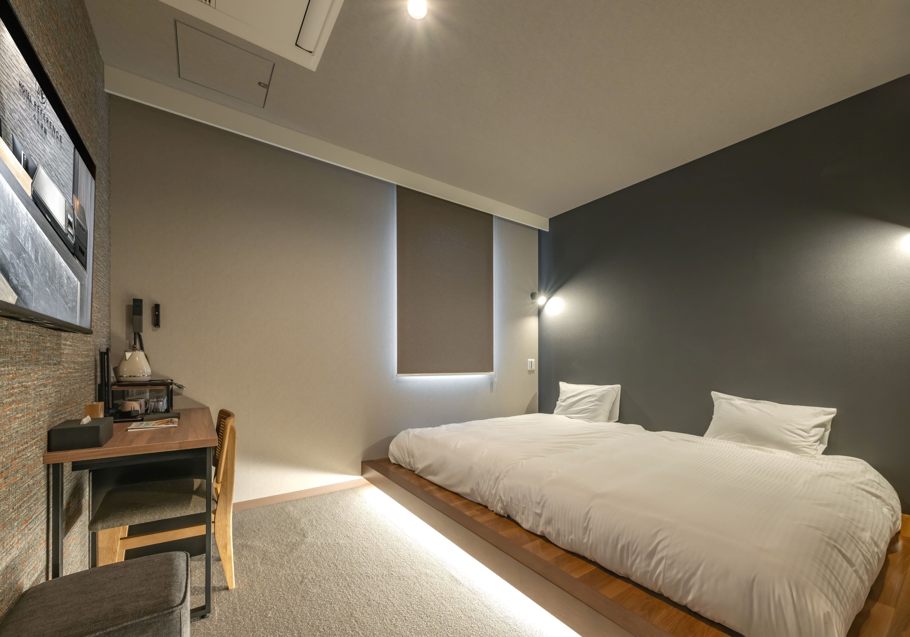 Un dormitorio con una cama, un escritorio y una silla.