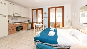 Une chambre à coucher avec un lit, une table de chevet, une fenêtre et une vue sur l’extérieur.