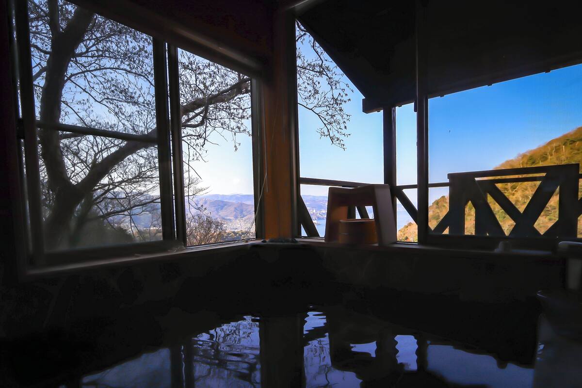 A room with a large window offering a view of a mountainous landscape.