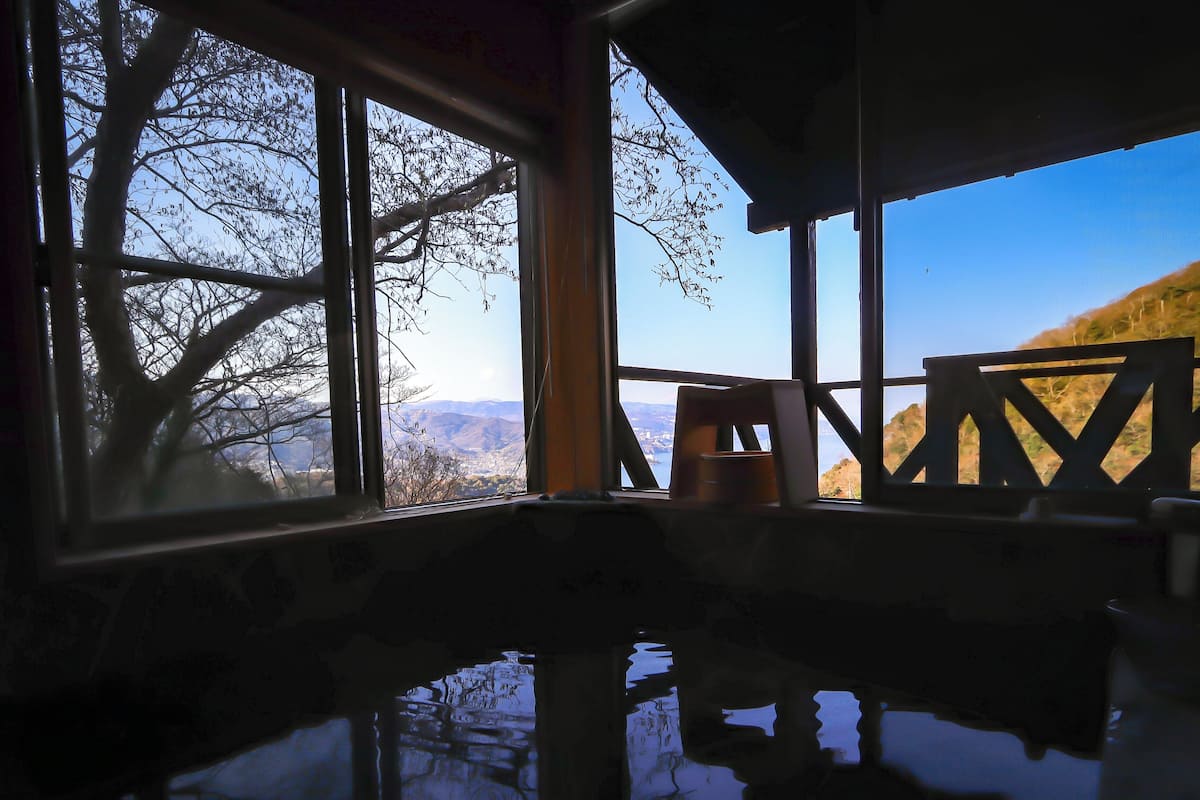 Una habitación con un amplio ventanal que ofrece vistas a un paisaje montañoso.