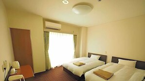 A hotel room with two beds, a desk with a telephone, an air conditioning unit, and a door. - Business Hotel Urbanty Nishikujo (Osaka)