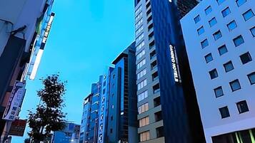 A modern hotel with multiple floors, large windows, and a prominent sign.
