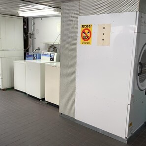 Un laboratorio con armarios blancos, un panel de control y un cartel de prohibido fumar.