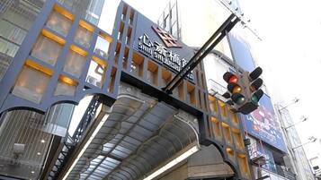 A modern building with a prominent sign, large windows, and a pedestrian overpass.