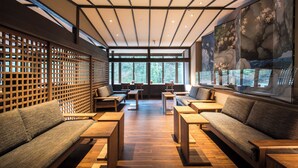 A modern interior with wooden furniture, a slatted wall, and a large window. - Kitashirakawa Natural Radium Onsen (Kyoto)