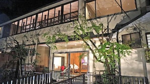 A multi-story building with a staircase, a balcony, and a view of the interior through a glass door. - Kitashirakawa Natural Radium Onsen (Kyoto)