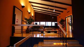 A modern interior with a staircase, a seating area, and a large window.