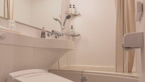 Et badeværelse med toilet, håndvask og bruser.