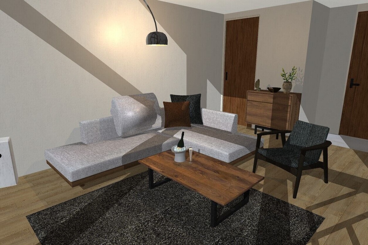 Una sala de estar moderna con sofá, mesa de centro y sillón, un aparador de madera y una lámpara colgante.
