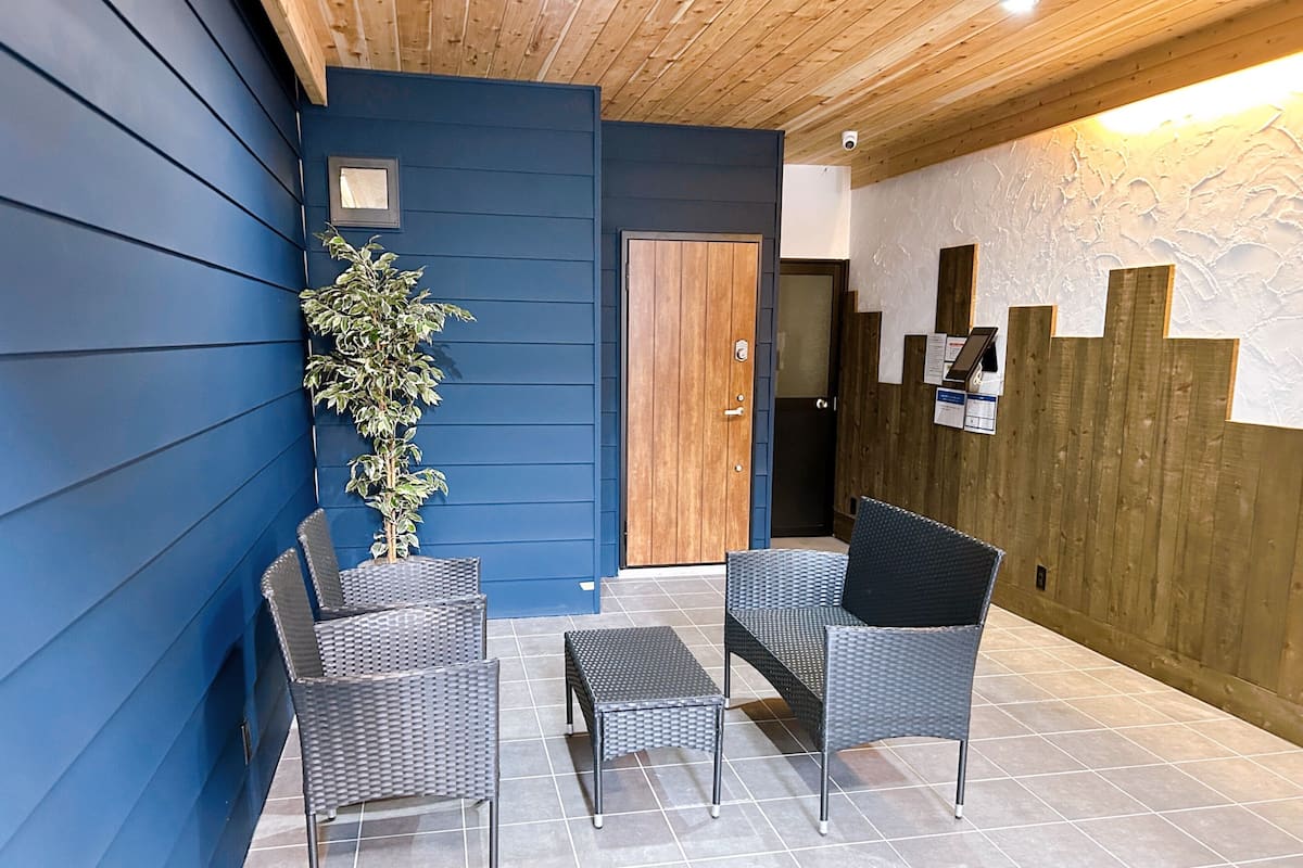 A room with a blue wall, a wooden door, and wicker furniture.