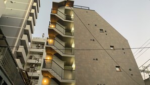 A multi-story building with balconies, a staircase, and a modern architectural design. - C&J Hotel (Tokyo)