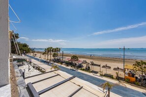 A coastal street with a beach view, palm trees, and outdoor seating areas. - Sea View Apartment | Durrës Waterfront by PikHost (Durrës)