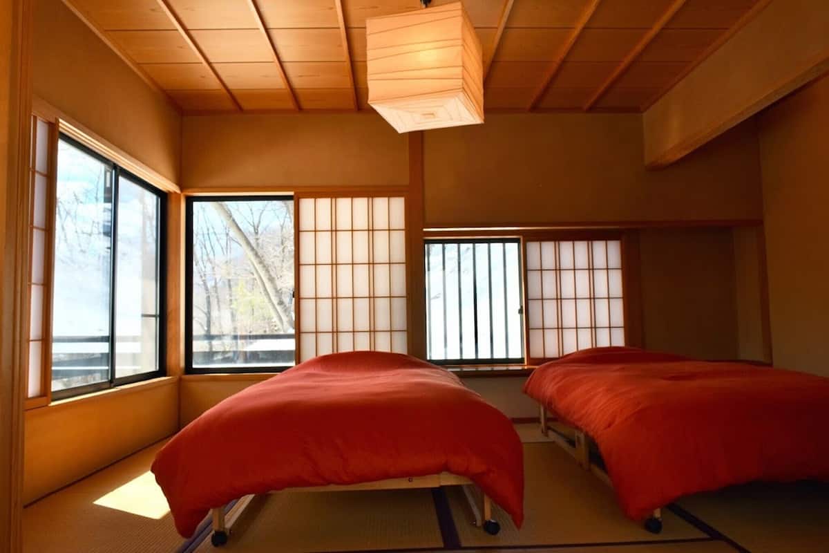Una habitación japonesa tradicional con suelo de tatami, paredes divisorias de papel y un futón.