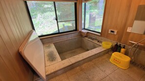 Ein Badezimmer mit Badewanne, Fenster, Toilette und Waschbecken.