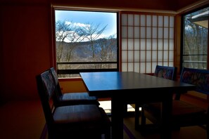 A room with a table and chairs, a large window with a view of trees and mountains, and a shoji screen. - Tabino Teitaku Miyagi Kawasaki (Kawasaki)