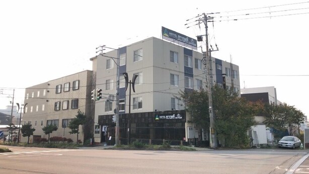 A multi-story hotel with a modern facade, a visible entrance, and a signboard indicating the hotel's name. - Tetra Hotel Yunokawa Hot Spring (Hakodate)