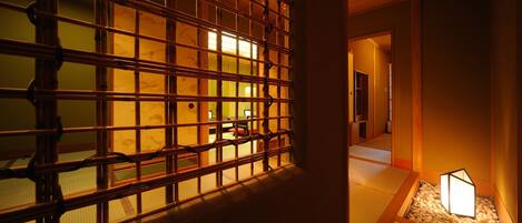 A traditional Japanese interior with tatami flooring, a shoji screen, and a small lantern.