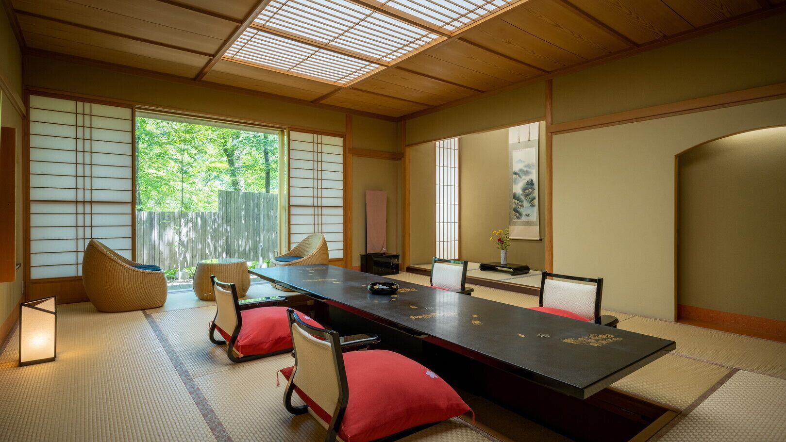Una habitación japonesa tradicional con suelo de tatami, una mesa baja y puertas correderas shoji.