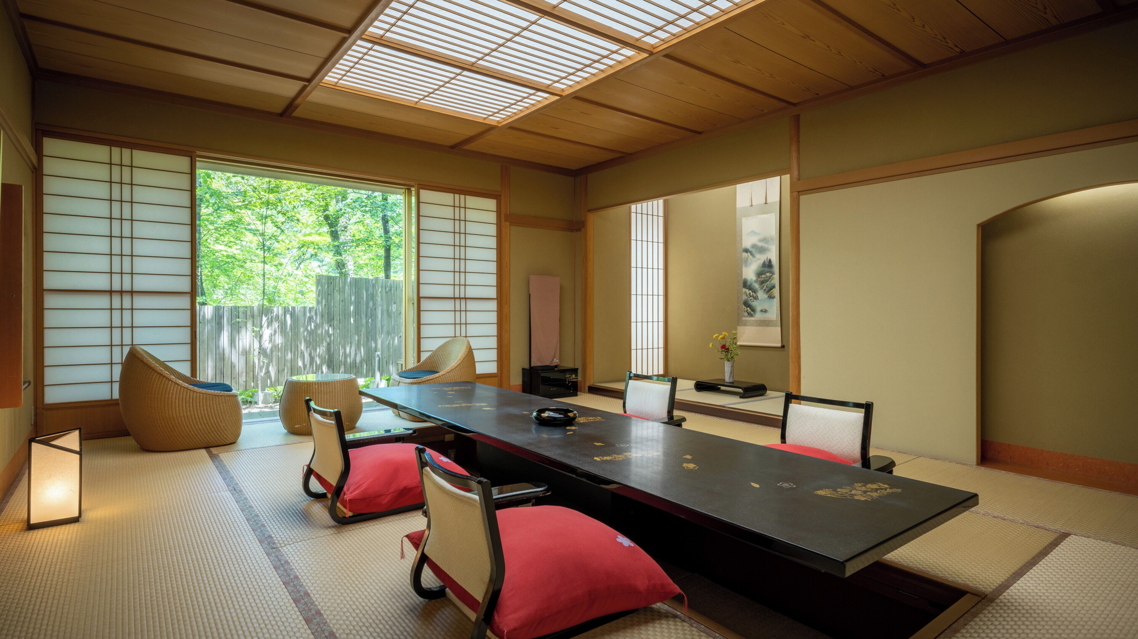 Una habitación tradicional japonesa con suelo de tatami, una mesa baja y puertas correderas shoji.