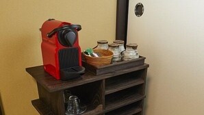 Eine Ecke mit einem dunklen Holzschrank, einem roten Gerät und Glasbehältern auf Regalen.