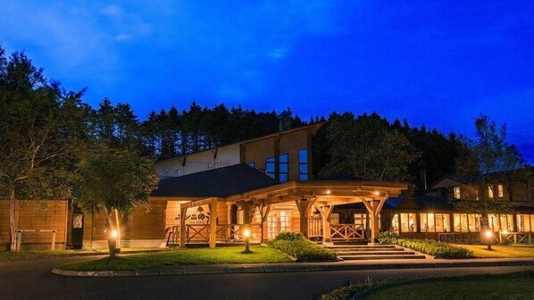 A two-story building with a covered porch and a well-lit entrance. - Yunni No Yu (Yuni)