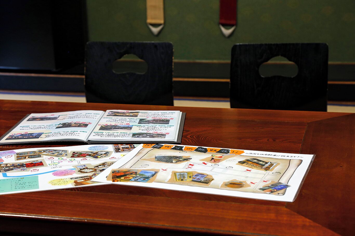 A wooden table with brochures and a folder.