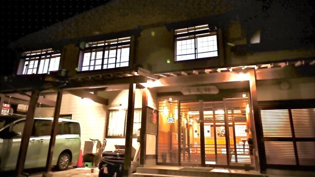 A building with a garage entrance, a car parked outside, and steps leading to the entrance. - Kinosaki Onsen Sanso Ashigaru Ryokan (Toyooka)