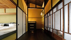 A traditional Japanese-style room with tatami flooring, sliding doors, and a bed with white bedding. - Kuraya Senbonsanjo (Kyoto)