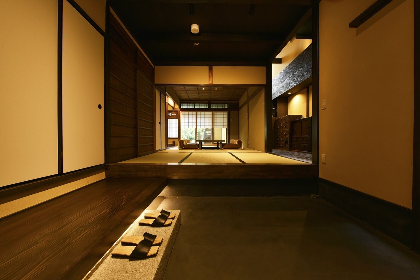 Una habitación japonesa tradicional con suelo de tatami, puertas correderas y techo bajo.