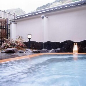 Una piscina con un muro de piedra y una pequeña cascada.