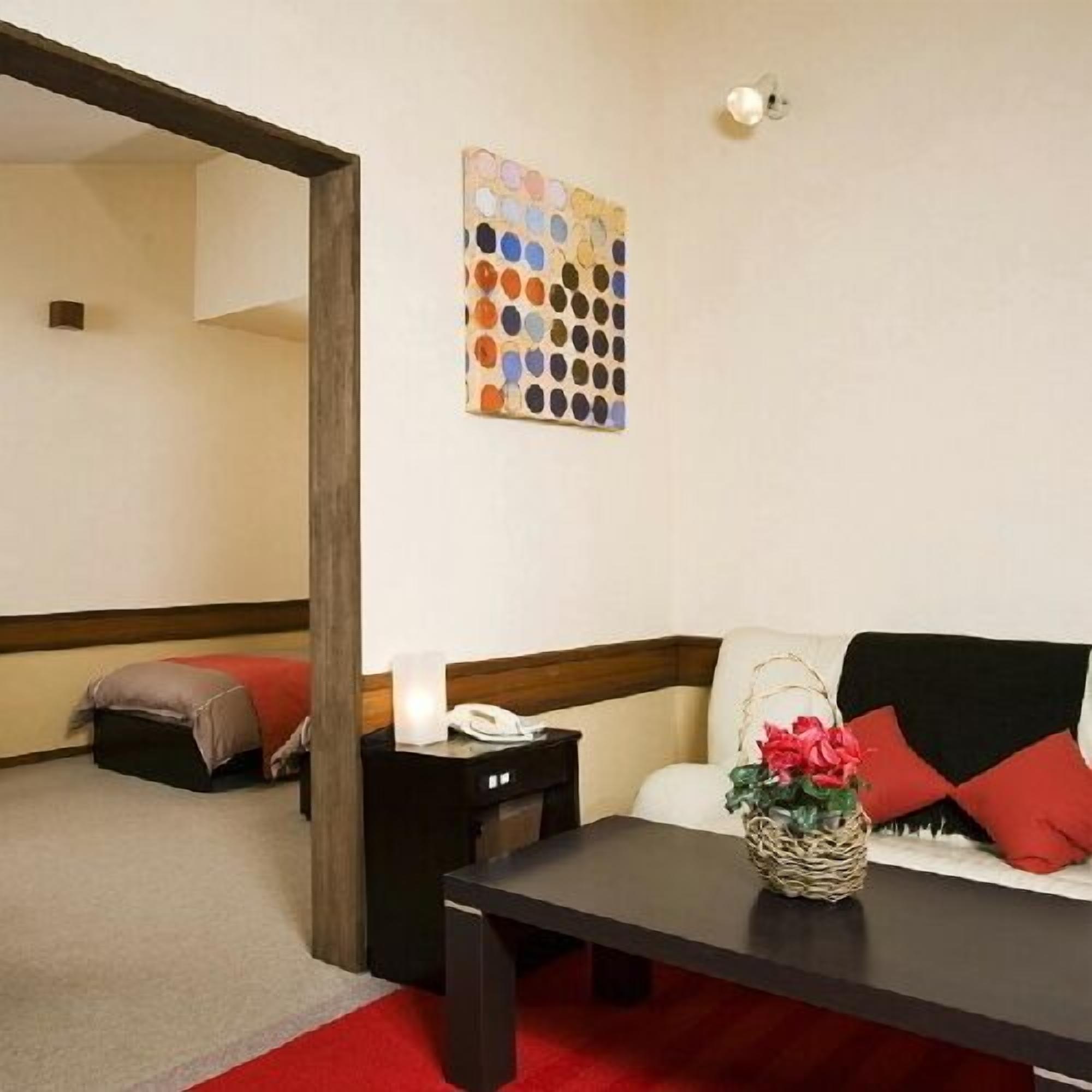 Una habitación con un sofá, una mesa, una lámpara y una obra de arte en la pared.