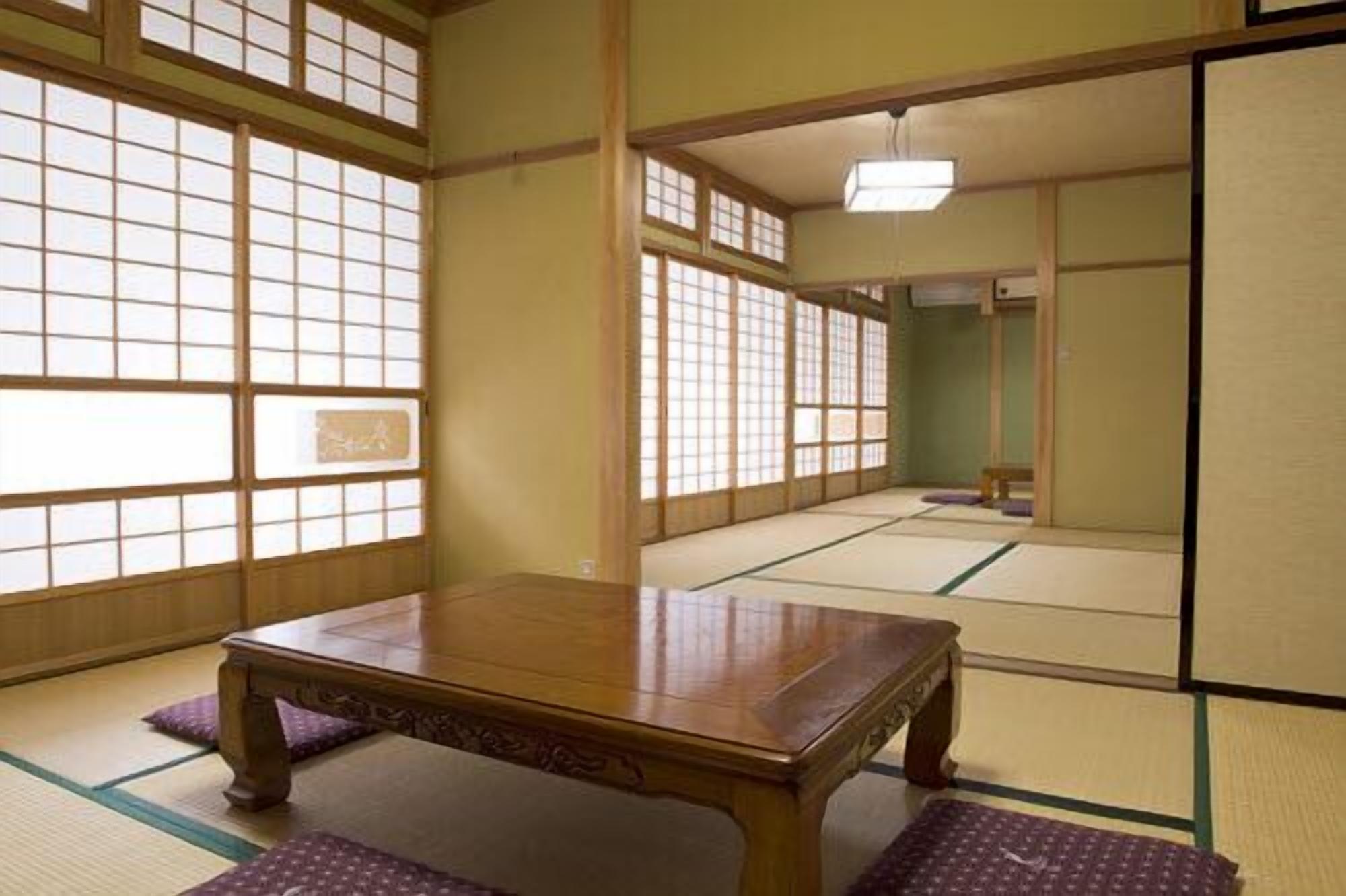 A traditional Japanese room with tatami flooring, a wooden table, and shoji screens.