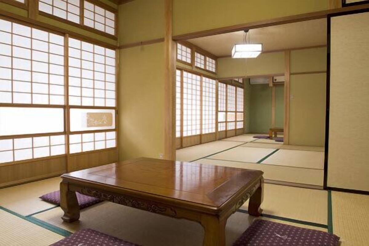 A traditional Japanese room with tatami flooring, a wooden table, and shoji screens.