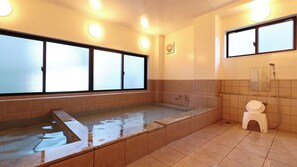 Une salle de bain avec une baignoire, des toilettes et un espace douche.
