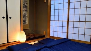 Une pièce de style japonais traditionnel, avec un sol recouvert de tatamis, une petite table en bois et un paravent en papier de riz (shoji).