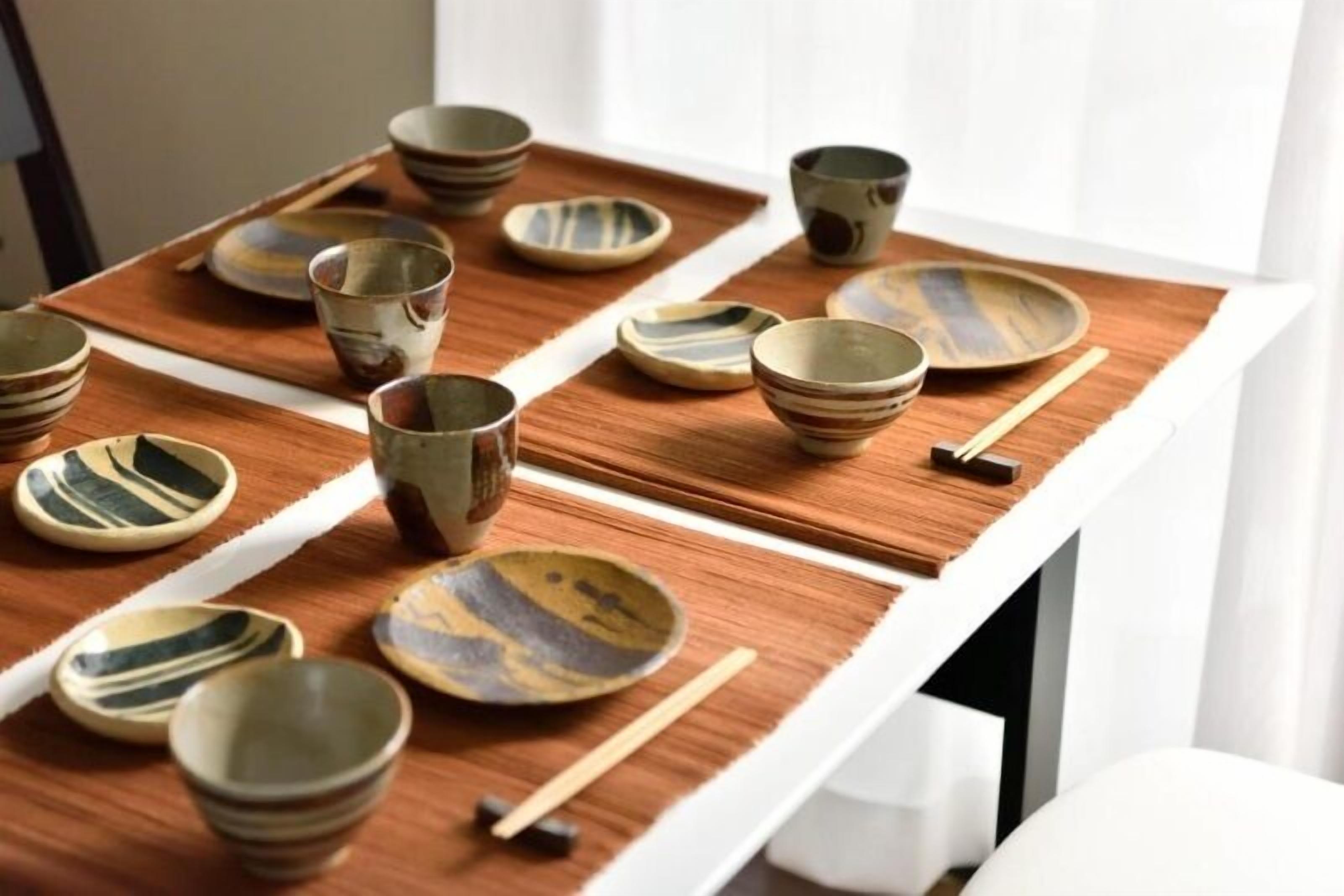 A table with various ceramic bowls and cups, arranged neatly on a tray.