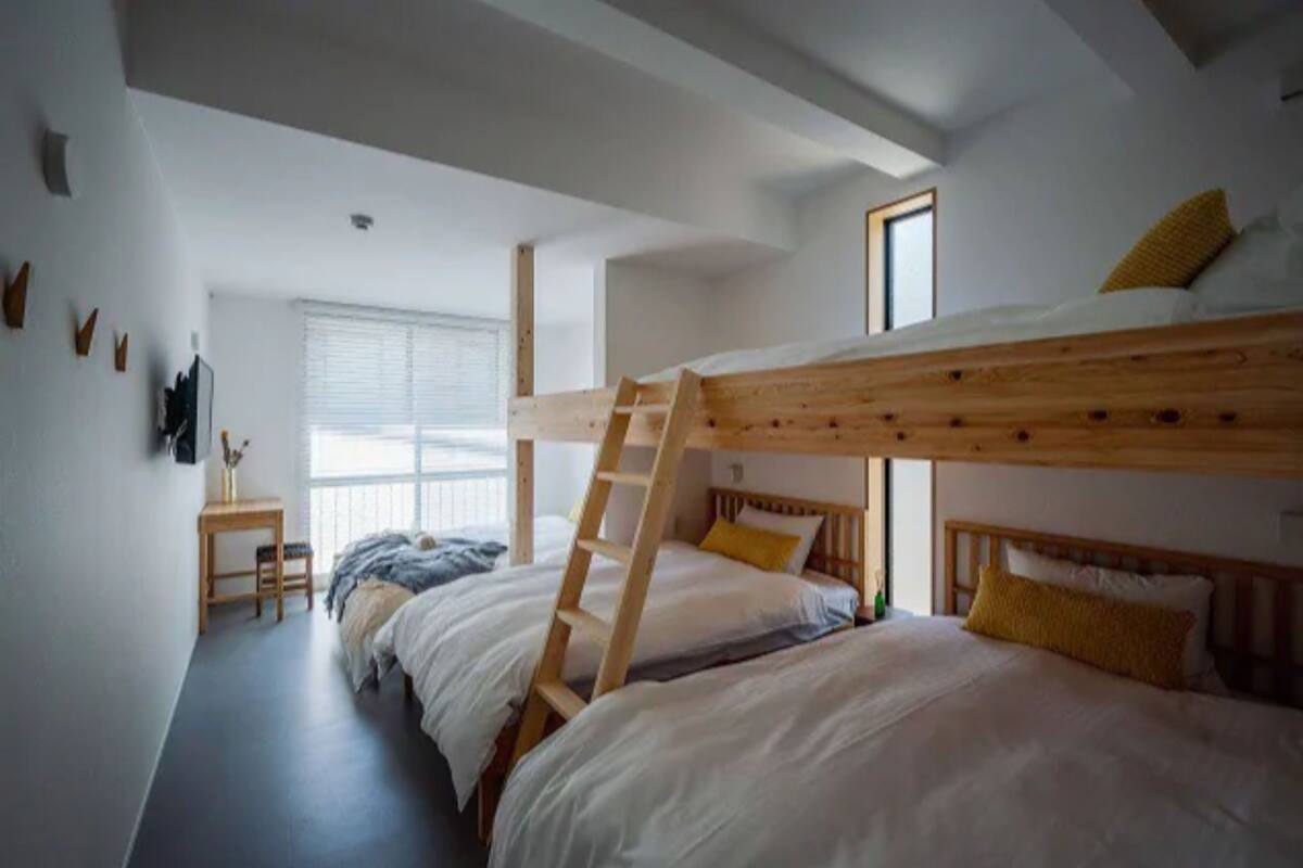 Dormitorio con literas, escritorio y ventana.