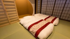 Um quarto com uma cama, uma porta deslizante e um tradicional painel japonês shoji.