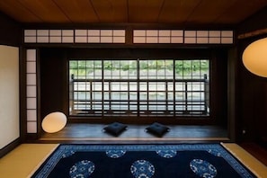 A traditional Japanese room with tatami flooring, a shoji screen, and a view of greenery outside. - Kyomachiya Yaeya Toichicho (Kyoto)