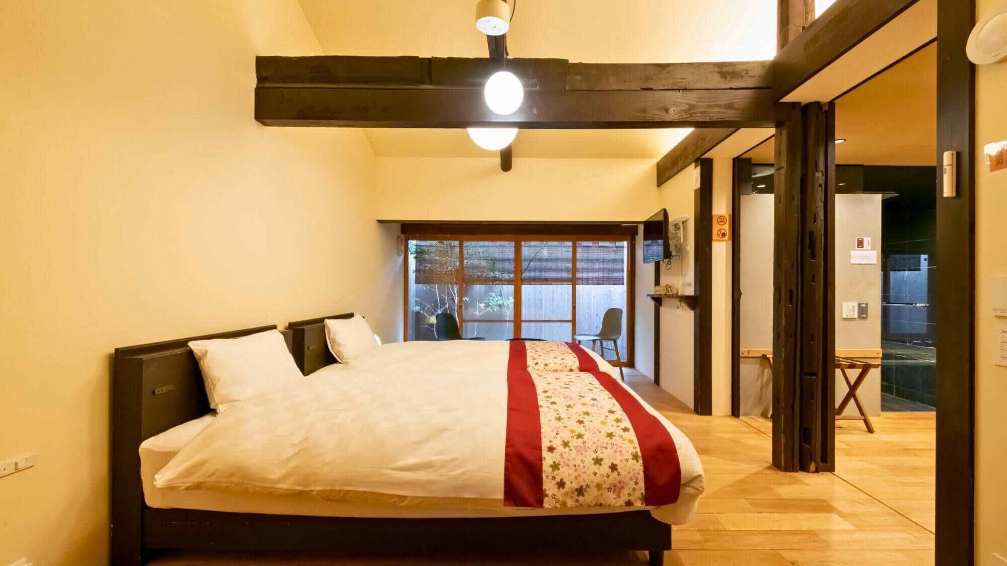 Un dormitorio con una cama, una ventana y una puerta que da a un balcón.
