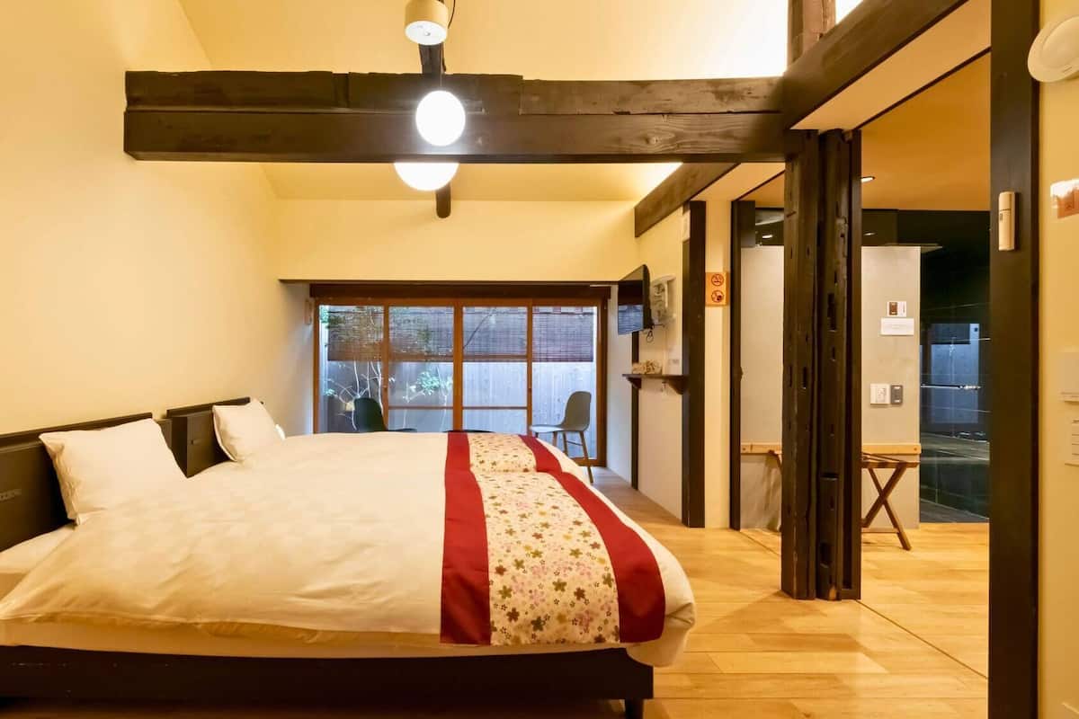 Un dormitorio con una cama, una ventana y una puerta que da a un balcón.