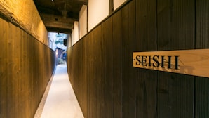 A narrow corridor with wooden walls and a sign reading 'SEISHI'. - Satoi Seishi Omiya Gojo (Kyoto)
