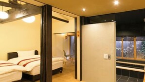 A modern hotel room with two beds, a kitchen area, and a view of the outdoors. - Satoi Seishi Omiya Gojo (Kyoto)