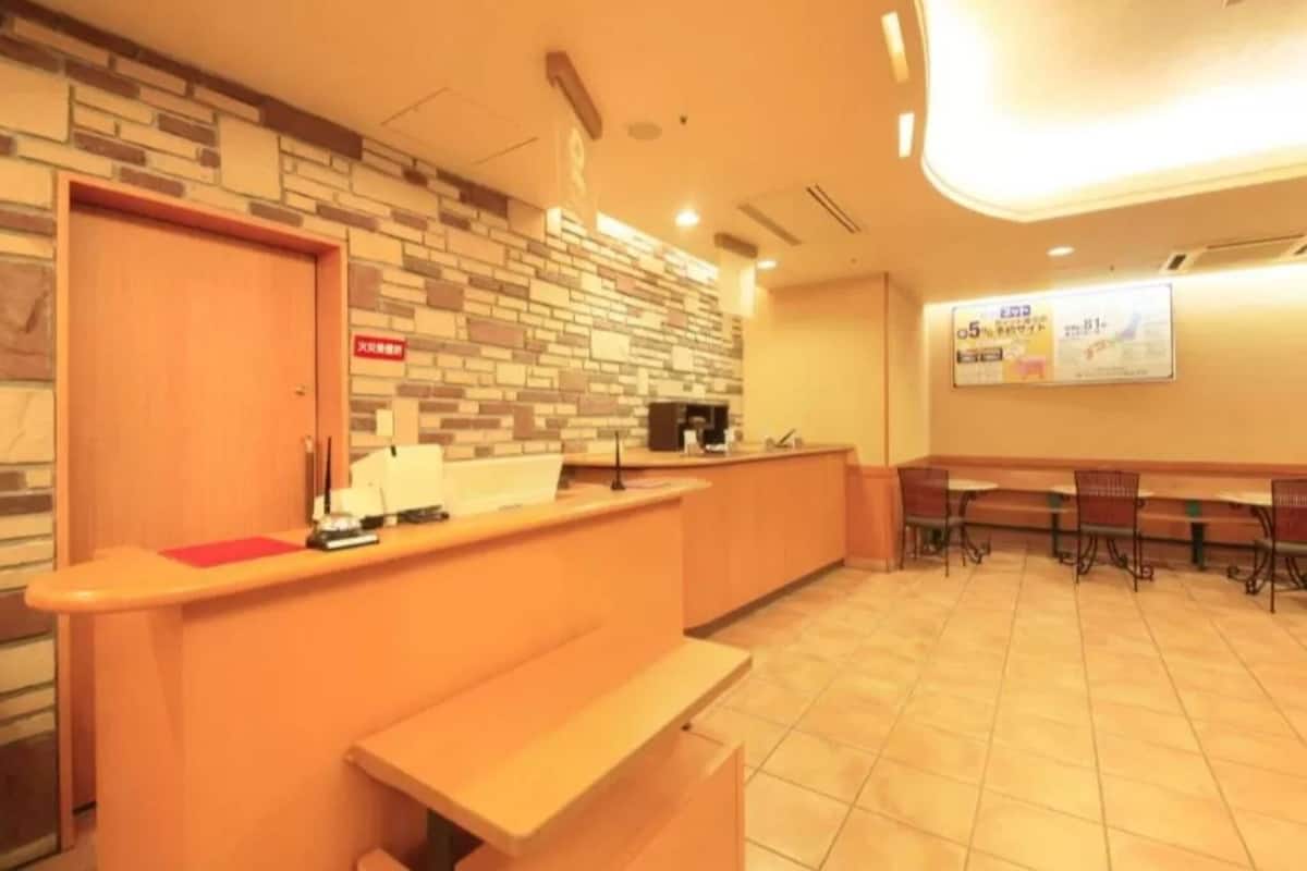 A reception area with a counter, a bench, and a wall with a patterned design.